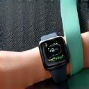 A sleek smartwatch, resistance bands, and a yoga mat laid out for a workout.